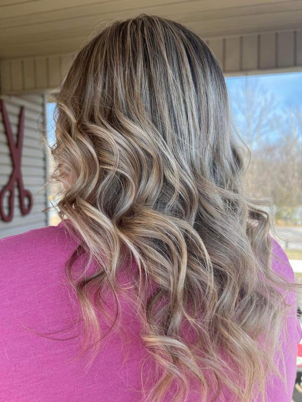 Loose beige blonde waves, photographed on the salon porch.