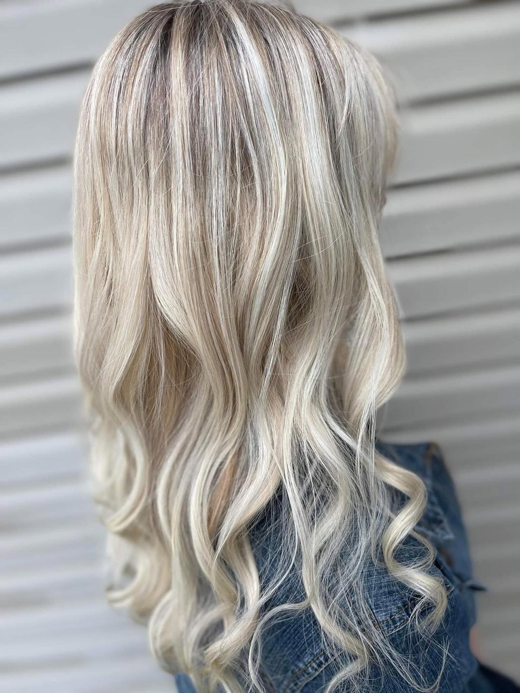 Long platinum blonde hair kept darker at the roots.